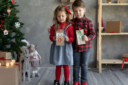 Children with handmade advent calendar gift bags. Christmas kids fan.の写真素材