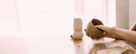 The potter works with clay, the hands of the master are close-up, makes a bowl from clay. Banerの写真素材