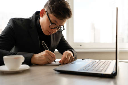 Businesswoman taking order online, writing on paper, businessman in office marketing ideas, freelancer morning, online training or jobの写真素材