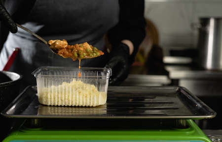 food delivery in the restaurant. Close-up of a gloved chef's hand weighing a batch of rice on an electronic scale. Small business. Takeout food. Copy space.の写真素材