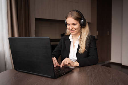 remote work concept. Caucasian woman in headphones works remotely on her laptop, freelancer or teacher has a video call consultation, millennial girlの写真素材