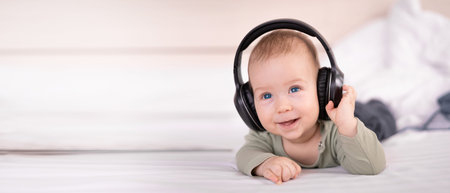 Laughing baby lying on bed listening music in headphones, wireless headset for education, baby 4...