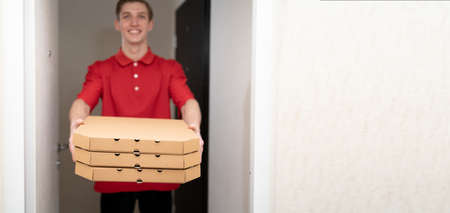 Pizza delivery home, deliveryman with pizza boxes at the door, food delivery service courier, bannerの写真素材