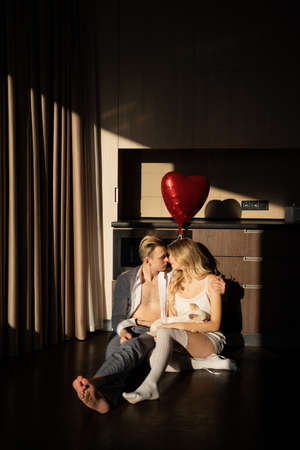 happy couple in love man and woman in the morning in the rays of sunlight hold a heart-shaped balloon in their hands. concept of valentine's day celebration, anniversary or anniversary.の写真素材