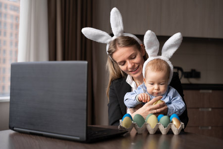 a woman and a child paint eggs for Easter, record lessons on a webcam with a laptop. copyspace.の写真素材
