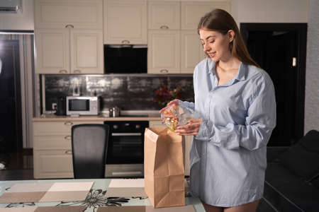 Unpacking takeaway food in eco package, girl takes out disposable dinnerware, keto diet and vegetables in containers, lifestyle food orderingの写真素材