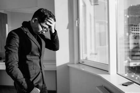 Worried businessman in suit, shocked by bad news at work, desperate bankrupt investor lost money online, overwhelmed by financial problems debts, frustrated worker tired of overwork. black and white.の写真素材