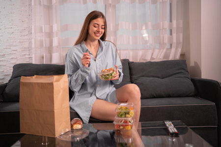 Girl holding paper plate container with healthy food. dinner at home disposable tableware. Food delivered to your home. Healthy meal concept. when you stay at home.の写真素材