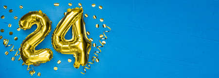 golden foil balloon number twenty four. Birthday or anniversary card with the inscription 24. blue concrete background. Anniversary celebration. Banner. copy spaceの写真素材