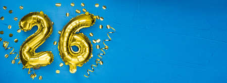 golden foil balloon number twenty six. Birthday or anniversary card with the inscription 26. blue concrete background. Anniversary celebration. Banner. copy spaceの写真素材