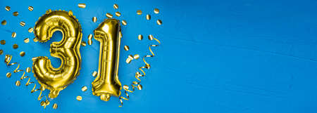 number thirty one gold foil balloon. Birthday or anniversary card with the inscription 31. blue concrete background. Anniversary celebration. Banner. copy spaceの写真素材