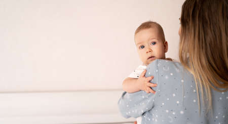 Caucasian mother and child close up. Mom holds the baby son in her arms, hugs him and enjoys, white background. happy family concept. banner, place for text. high quality photoの写真素材