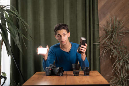 arab The guy-photographer is recording a video lesson for photographers talking about different light sources, constant and pulsed. Online photography training, courses for photographers. copyspace.の写真素材
