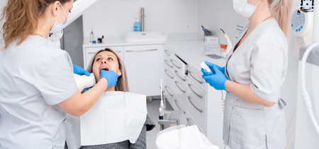 Dentist's hands take a jaw x-ray for a young woman in a dental clinic. The concept of dental...