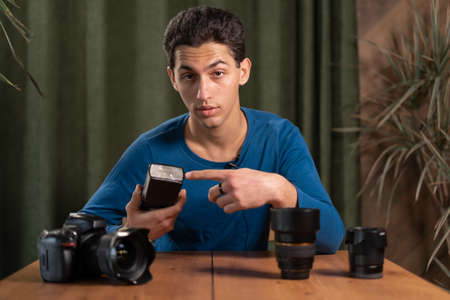 The photographer guy makes an overview of the flash settings and the camera records a video tutorial. Online photography training, photography courses. webcam viewの写真素材