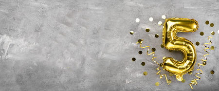 Yellow foil balloon number, number five on a concrete background. Birthday card with lettering 5. Anniversary concept. for anniversary, birthday, new year celebration. banner, copy space.の写真素材