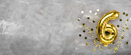 Yellow foil balloon number, number six on a concrete background. Birthday card with lettering 6. Anniversary concept. for anniversary, birthday, new year celebration. banner, copy space.の写真素材