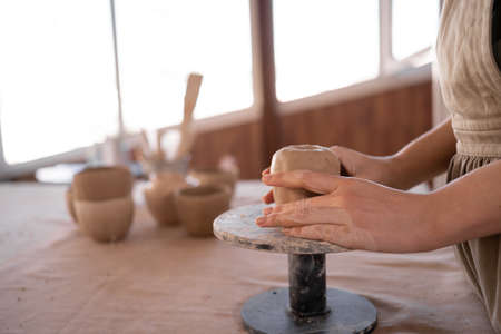 close-up female hands of a potter making a cup in traditional style. Hands sculpt dishes from clay,の写真素材