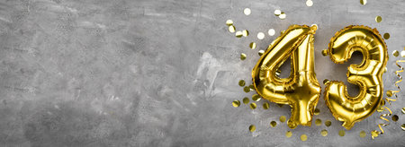 Yellow foil balloon number, number forty three concrete background. Greeting card with the inscription 43. Anniversary concept. for anniversary, birthday, new year celebration. banner, copy space.の写真素材