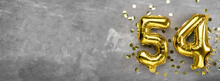 Yellow foil balloon number, number fifty four concrete background. Greeting card with the inscription 54. Anniversary concept. for anniversary, birthday, new year celebration. banner, copy space.の写真素材