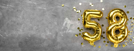 Yellow foil balloon number, number fifty eight on a concrete background. Greeting card with the inscription 58. Anniversary concept. for anniversary, birthday, new year celebration. banner, copy space.の写真素材