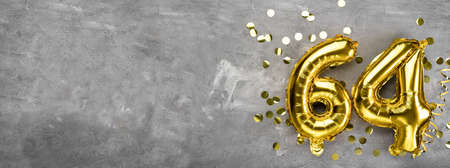 Yellow foil balloon number, number sixty four on a concrete background. Greeting card with the inscription 64. Anniversary concept. for anniversary, birthday, new year celebration. banner, copy space.の写真素材