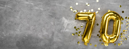 Yellow foil balloon number, number seventy on a concrete background. Greeting card with the inscription 70. Anniversary concept. for anniversary, birthday, new year celebration. banner, copy space.の写真素材