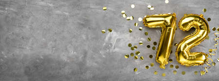Yellow foil balloon number, number seventy two on a concrete background. Greeting card with the inscription 72. Anniversary concept. for anniversary, birthday, new year celebration. banner, copy space.の写真素材
