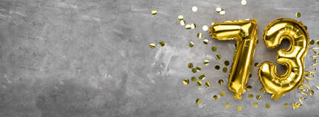 Yellow foil balloon number, number seventy three on a concrete background. Greeting card with the inscription 73. Anniversary concept. for anniversary, birthday, new year celebration. banner, copy space.の写真素材