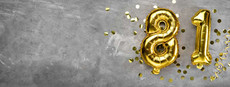 Yellow foil balloon number, number eighty one on a concrete background. Greeting card with the inscription 81. Anniversary concept. for anniversary, birthday, new year celebration. banner, copy space.の写真素材
