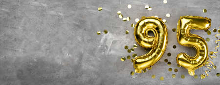 Yellow foil balloon number, number ninety-five on a concrete background. Greeting card with the inscription 95. Anniversary concept. for anniversary, birthday, new year celebration. banner,の写真素材