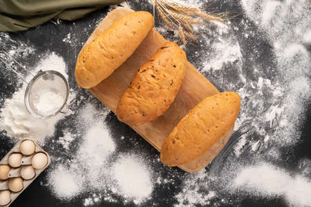 three loaves of bread made from wheat, corn and rye flour. Variety of bakery products on a wooden background. mini bakery concept.の写真素材