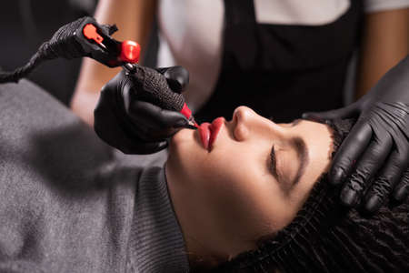 Portrait of the master during the application of permanent makeup on the lips. Tattoo on the face and micropigmentation of the lips. Professional facial microblading.の写真素材
