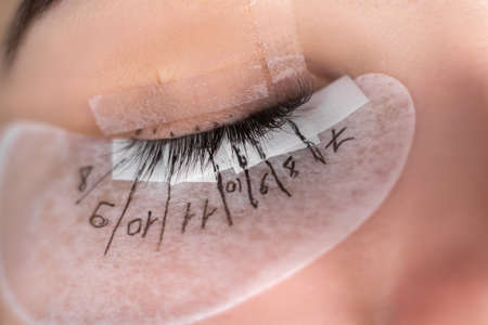 Eyelash extensions in a beauty salon. training and labeling. female eye close up.の写真素材