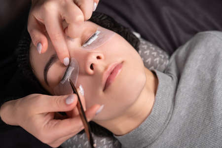 eyelash extension procedure. female eye before the process. The master makes preparations for the procedure.の写真素材