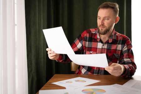 Man sign a home insurance policy on home loans, Agent holds loan investment chart graph documents and calculating table installment payment, Real Estate concept.の写真素材
