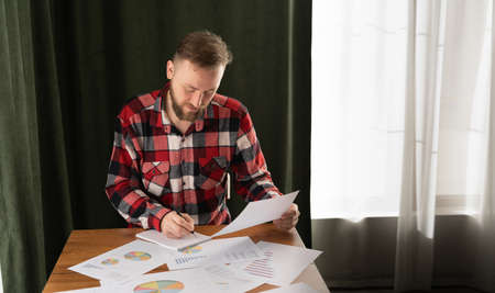 Man sign a home insurance policy on home loans, Agent holds loan investment chart graph documents and calculating table installment payment, Real Estate concept.の写真素材