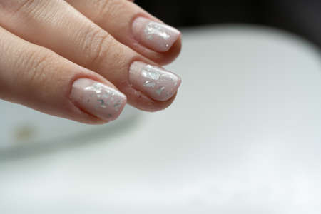 Female hand fingers close-up with overgrown shellac manicure two months after application, needs correctionの写真素材