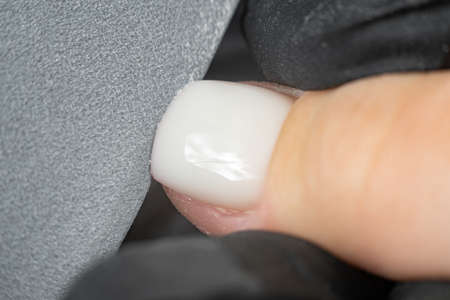 close-up. Macro of a nail file. The process of cutting nails. Woman doing her own manicure in a spa salon,の写真素材