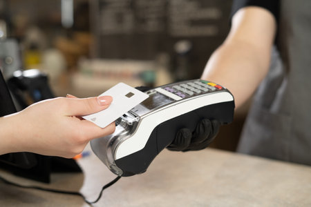 Contactless debit card payment, customer hand paying contactless credit card with NFC technology....