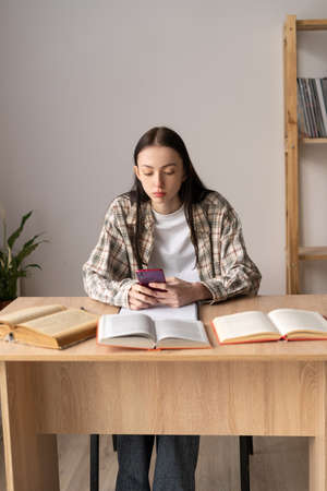 online learning concept, asian college student studying using smart phone and online lecture, distance education, remote college student, asian girl using study appの写真素材