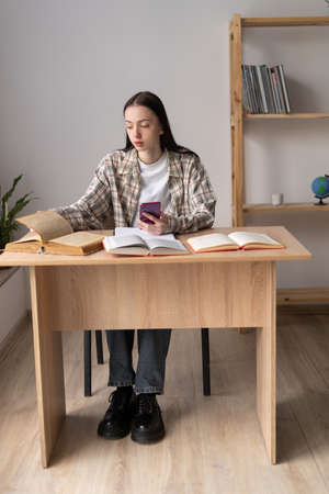 distance education, college student studying remotely using modern smartphone, online lesson at home, technology for e-learning, vertical viewの写真素材