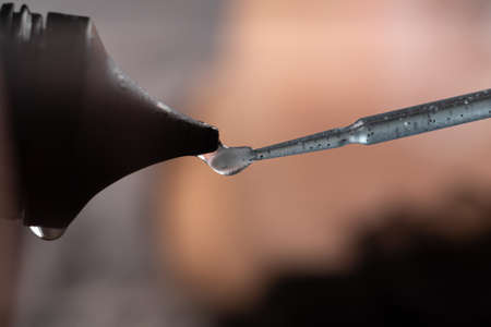 Glue for eyelashes squeezed out of a tube with a soft brush, a drop of glue close-up, macroの写真素材