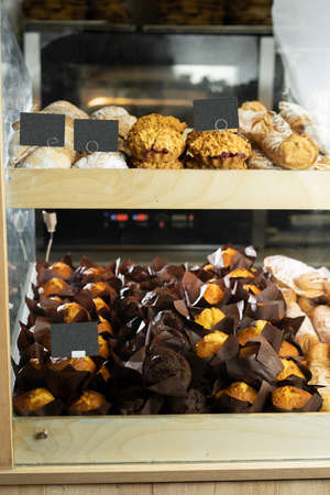 Confectionery in bakery cafe with fresh muffins and sweets, bakery department showcase in store, fresh pastries conceptの写真素材