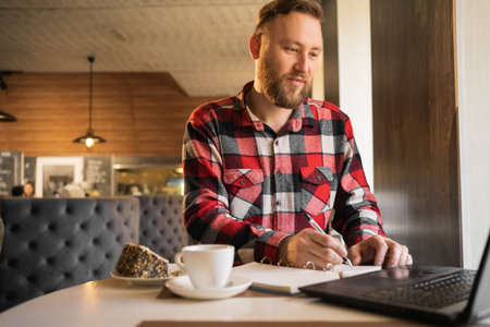 Businessman having coffee and doing his work in cafe. male employee pondering considering idea looking at computer screen making decisionの写真素材