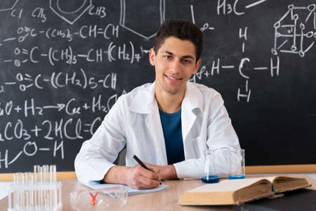 muslim young teacher leading chemistry lesson at school, chemistry science and experience in college lab, arabic student sitting at tableの写真素材