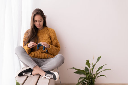 Woman crocheting. Handwork. Crochet hook. female hands hold a hook and knit a scarf. handmade knitting. Home hobbyの写真素材