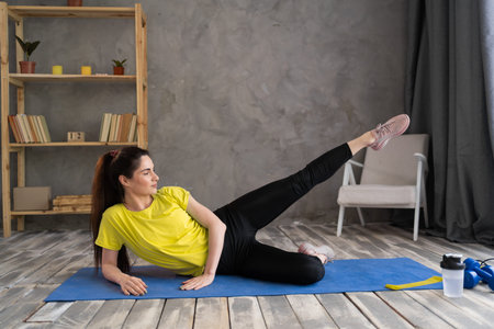 young athletic woman doing fitness leg stretching exercises on fitness mat at home. sport, fitness...