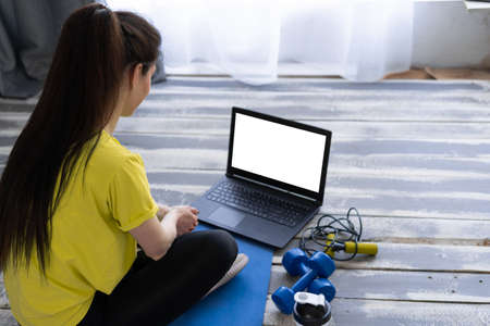 Young sporty woman preparing for online fitness training with modern laptop. online fitness and sport lessons. Healthy lifestyleの写真素材