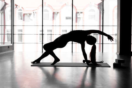 woman lotus pose yoga Padmasana posture position in silouhette on studio whiteの写真素材